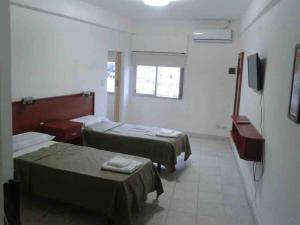una camera d'albergo con due letti e una televisione di Premier a Santiago del Estero