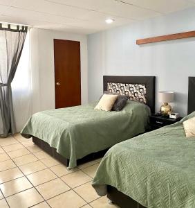 een slaapkamer met 2 bedden en een raam bij Posada Catalina in Zacatlán