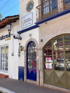 a store with doors and windows on a street at Posada Catalina in Zacatlán