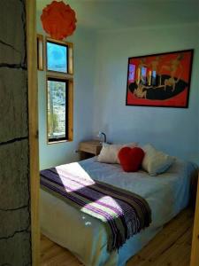 a bedroom with a bed with a red heart pillow at Santuario Cósmico in Vicuña