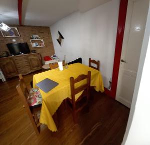 a dining room table with a yellow table cloth on it at Espacio de arte físico in Buenos Aires +6 photos