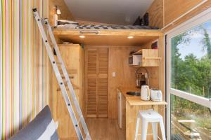a tiny kitchen with a ladder in a tiny house at Rural Couples Retreat/Tiny House in Pukehina