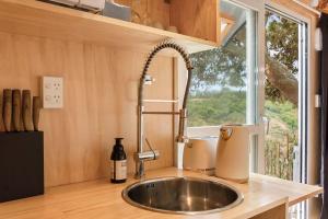 um lavatório numa cozinha com uma janela em Rural Couples Retreat/Tiny House em Pukehina