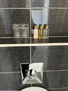 a bathroom with a toilet and a shelf with bottles at MB Apartments in Ulcinj