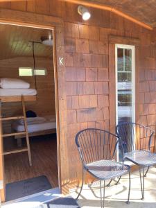 a patio with two chairs and a bunk bed at The Hiker Huts at Wild Coast Wilderness Resort in Port Renfrew