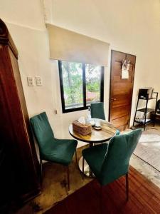 une salle à manger avec une table et des chaises vertes dans l'établissement ASRI Villas, à Valencia