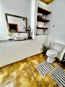 a bathroom with a toilet and a sink and a mirror at ASRI Villas in Valencia
