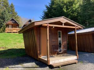 a small cabin with a chair sitting on a porch at The Hiker Huts in Port Renfrew