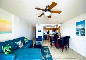 a living room with a blue couch and a ceiling fan at SunSwept 505 by ALBVR - Beachfront condo at a great location! in Orange Beach
