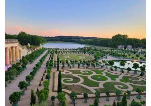 Superbe appartement avec jardin proche Versailles في سا سير لوكول: اطلالة جوية على حديقة مع بحيرة