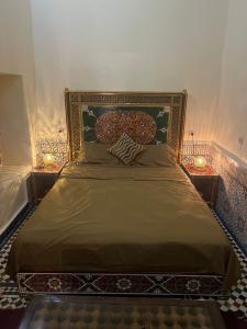 een slaapkamer met een bed met twee verlichting bij Riad Ranya in Fès