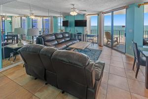 a living room with a leather couch and a table at Phoenix East 801 by ALBVR - Corner unit with wrap-around balcony and unparalleled views! in Orange Beach