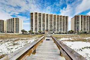 a wooden boardwalk leading to the beach with tall buildings at Phoenix East 801 by ALBVR - Corner unit with wrap-around balcony and unparalleled views! in Orange Beach
