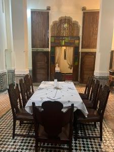 een eetkamer met een lange tafel en stoelen bij Riad Ranya in Fès