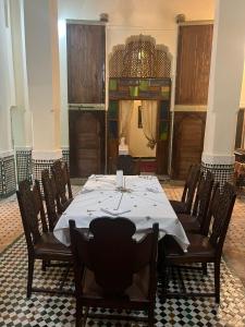 a dining room with a long table and chairs at Riad Ranya in Fez