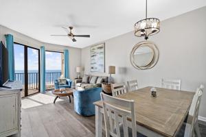 奧蘭治海灘的住宿－Phoenix VII 71113 by ALBVR - Beautiful Beachfront Condo with Amazing Views & Amenities!，用餐室以及带桌椅的起居室。