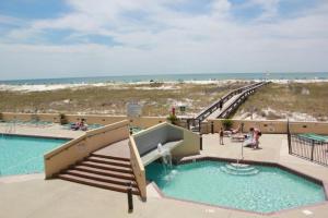 a swimming pool with a fountain and stairs next to the beach at Phoenix VII 71113 by ALBVR - Beautiful Beachfront Condo with Amazing Views & Amenities! in Orange Beach