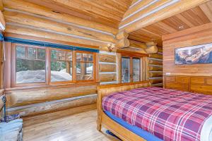 a bedroom with a bed and windows in a log cabin at Seattle Mountain Home in Snoqualmie Pass