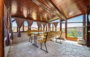 a dining room with a table and benches and windows at Amazing Home In Mali Iz With Kitchen in Mali Iž