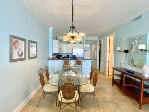 a dining room with a glass table and chairs at Island Royale P403 by ALBVR - Beautiful Beachfront Penthouse Level Condo! in Gulf Shores