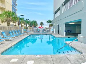 a swimming pool with chairs and a building at Island Royale P403 by ALBVR - Beautiful Beachfront Penthouse Level Condo! in Gulf Shores