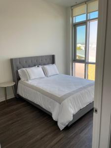 a bedroom with a large bed with a window at Las Palmas - Modern, Stylish, Spacious, Secure & Tranquil Condo with 2 Master Suite Bedrooms - WLK to SM Pier in Los Angeles