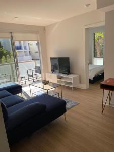 a living room with a blue couch and a television at Las Palmas - Modern, Stylish, Spacious, Secure & Tranquil Condo with 2 Master Suite Bedrooms - WLK to SM Pier in Los Angeles