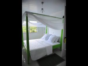 ein Schlafzimmer mit einem weißen Bett mit Baldachin in der Unterkunft Le PatBle au Makaré Lagoon Club in Le Vauclin