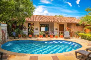 a swimming pool in front of a house at Hotel Casa Canela in Barichara