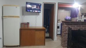 a kitchen with a refrigerator and a tv on the wall at Bahía Estrada MDP in Mar del Plata