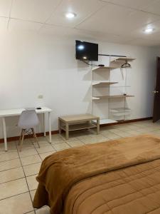 una camera con letto, scrivania e TV di Posada Catalina a Zacatlán