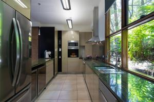 a large kitchen with glass countertops and a large window at Eumarella Shores Noosa Lake Retreat in Noosaville +63 photos