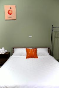 a bed with an orange pillow on top of it at 上海民宿 in Chaozhou