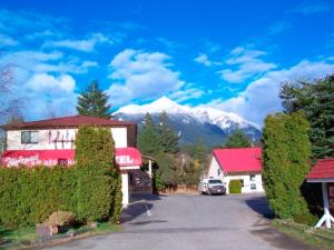 a street in a village with a mountain in the background at Red Roof Motor Inn in Hope