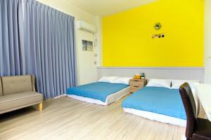 1 dormitorio con 2 camas y pared amarilla en 上海民宿, en Chaozhou