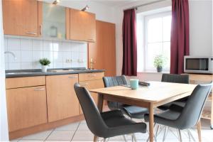 uma cozinha e sala de jantar com uma mesa de madeira e cadeiras em BreitlingBlicke em Gollwitz