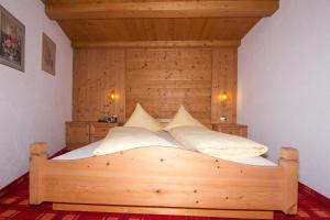 a bedroom with a bed with a wooden headboard at Fiegl Alois in Längenfeld