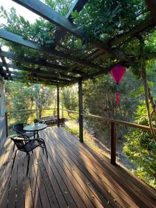 una terrazza in legno con tavolo e ombrellone di Serenity on Stanthorpe a Fleurbaix