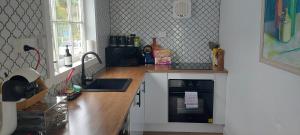 a kitchen with a counter with a sink and a stove at The Artists Cottage - absolute waterfront in Strahan