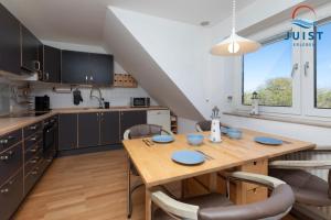 una cucina e una sala da pranzo con tavolo e sedie in legno di Haus Hahntje 192 - Wohnung Sonnenwinkel a Juist