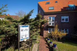 un cartello di fronte a una casa di mattoni di Haus Hahntje 192 - Wohnung Sonnenwinkel a Juist