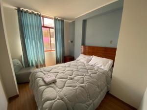 Un dormitorio con una cama grande y una ventana en EL GRAN SEÑORIAL, en Jauja