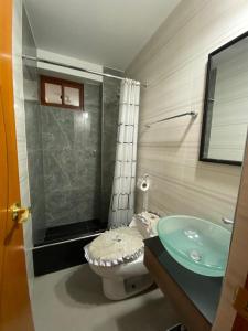 baño con lavabo verde y aseo en EL GRAN SEÑORIAL, en Jauja