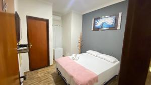 a bedroom with a bed with a pink blanket and a television at Pousada Ramalio in Maragogi +10 photos