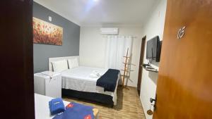 a small room with a bed and a television at Pousada Ramalio in Maragogi