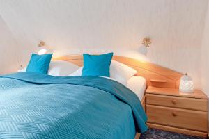 een slaapkamer met een blauw en wit bed en een nachtkastje bij Haus Schwanensee Seeblick Bischofsee in Bosau