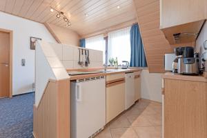 een keuken met witte apparatuur in een kamer bij Haus Schwanensee Seeblick Bischofsee in Bosau