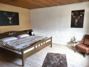 a bedroom with a large bed and a chair at Regal Apartment in Pracht with Garden and Grill in Pracht