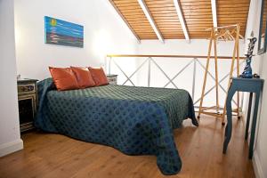 sypialnia z łóżkiem z zieloną kołdrą w obiekcie Apartamentos La Casa de la Alameda w mieście Medina Sidonia