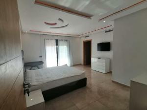 - une grande chambre avec un lit et une télévision dans l'établissement magnifique villa de vacances, à Marrakech